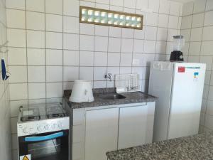 a small kitchen with a sink and a refrigerator at Flat do Golfinho in Tamandaré