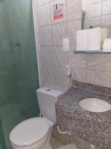 a bathroom with a toilet and a sink at Flat do Golfinho in Tamandaré +22 photos