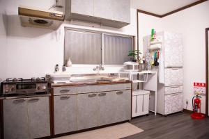 a kitchen with stainless steel appliances and a refrigerator at Kanchi Guesthouse in Osaka