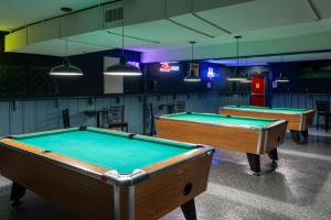 two pool tables in a room with lights at Budget Inn & Suites Baton Rouge in Baton Rouge