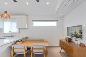 a kitchen with a wooden table and two chairs at Jeju Stone Courtyard Pension in Jeju