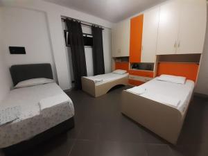 two beds in a room with orange and white at Villas for rent Elena feeling home in Durrës