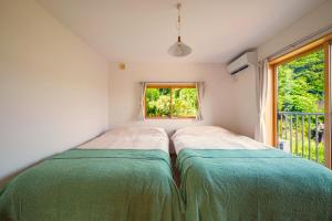 a small bedroom with a bed and a window at 愛犬と暮らすように過ごせる一棟貸しヴィラ イヌサウナリゾート伊豆白浜 in Shimoda