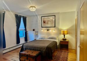 a bedroom with a bed and a large window at Super Spacious 2 bedroom Clinton Hill Garden Duplex in Brooklyn