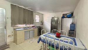 a kitchen with a table and a sink and a refrigerator at House for COP30 in Cidade Nova for up to 8 People i175 in Ananindeua