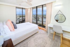 une chambre avec un lit et un bureau avec un miroir dans l'établissement Elevate Surfers Ocean & City Skyline Views, à Gold Coast