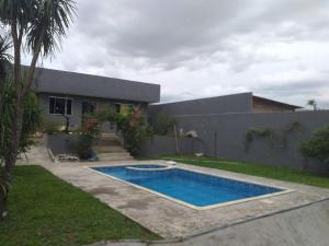 a swimming pool in front of a house at Por do sol piscina e skate e churrasco in Piraquara