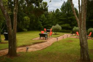 a patio with red chairs and a table in a park at El valle Muisca in Guasca