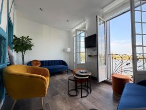 a living room with a blue couch and a window at Chez Fil'O in La Bouille