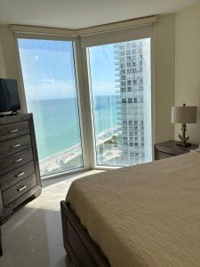a bedroom with a bed and a view of the ocean at Luxurious 2BD Condo with Direct Ocean Views & Resort Pool in Sunny Isles in Sunny Isles Beach +74 photos