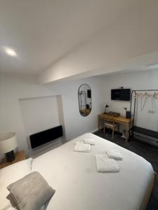 a bedroom with a white bed with two towels on it at The White Lion Hotel in Bridgend