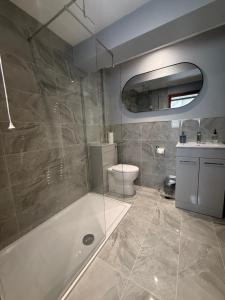 a bathroom with a tub and a toilet and a sink at The White Lion Hotel in Bridgend