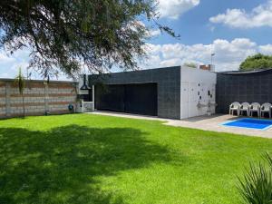 un gran patio con un edificio con garaje en Casa Mezquite, en Tequisquiapan