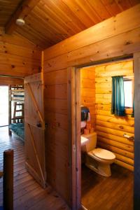 a bathroom with a toilet in a log cabin at Fremont RV Campground Cottage 21 in Fremont