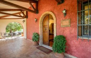a house with a red wall with a wooden door at Gorgeous Home In Rivodutri in Apoleggia