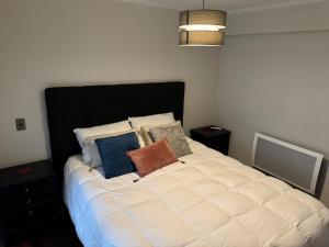 a bedroom with a large white bed with pillows at Nueva casa 6 personas en condominio cerrado in Temuco