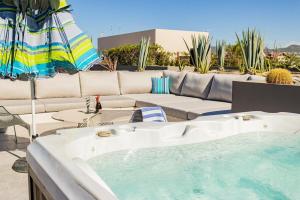 a bath tub sitting next to a couch and an umbrella at Nauti Baja Condo at The Marina Near the Beach in Cabo San Lucas
