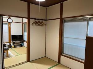 a living room with a large window and a clock at D-pdal Inn 1F - Vacation STAY 14134 in Tokyo