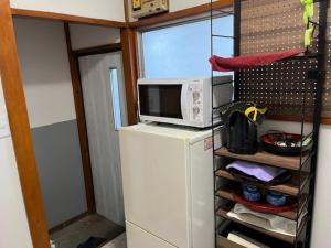 a microwave on top of a refrigerator in a kitchen at D-pdal Inn 1F - Vacation STAY 14134 in Tokyo +8 photos