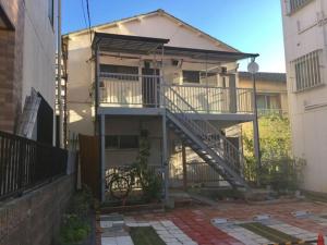 a house with a staircase in front of a building at D-pdal Inn 1F - Vacation STAY 14134 in Tokyo