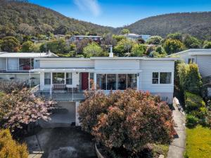 Vue aérienne d'une maison blanche avec des montagnes en arrière-plan dans l'établissement Delightful Delta - 3 Bedroom House - Taroona, à Taroona