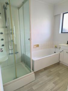 ein Badezimmer mit Dusche und Badewanne in der Unterkunft City Town House - Unit in Christchurch