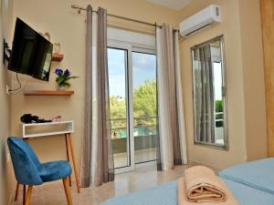 a bedroom with a large window and a tv at Elegant Villa with Pool & Garden in Eleousis in Kalithies