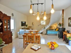 a kitchen and living room with a table with a bowl of fruit at Elegant Villa with Pool & Garden in Eleousis in Kalithies