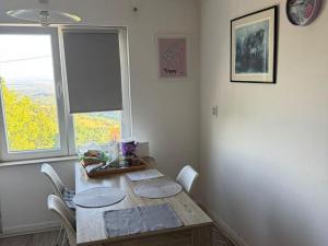 un tavolo da pranzo con sedie e una finestra di Plesivica Hillside HolidayHome Hot-Tub - 1 Bedroom a Jastrebarsko