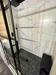 een douche met een witte marmeren muur in een badkamer bij luna y sol  +6 foto's