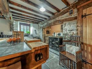 una cocina con paredes de madera y una pared de piedra. en Ynywsen Dairy Flat, en Llanfynydd