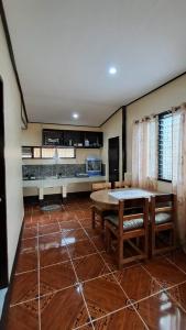 a living room with a table and benches at Charity Pension House in San Vicente