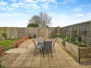 a patio with a table and chairs and a fence at The Barn in Martham