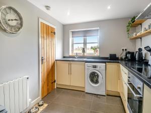 a kitchen with a washing machine and a sink at The Barn in Martham