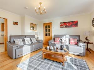 Una sala de estar con dos sofás y una mesa de café. en Bramble Cottage, en Gairloch