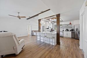 a kitchen and living room with white walls and wood floors at Your Perfect Port Charlotte Retreat in Murdock +28 photos