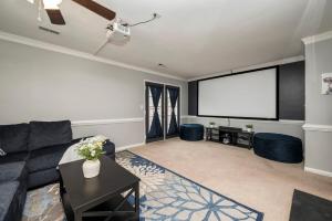 a living room with a couch and a screen at Waterfront Retreat with Dock, Firepit & Theater in Portsmouth