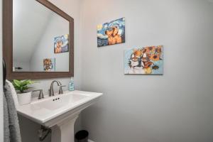 a bathroom with a sink and some pictures on the wall at Waterfront Retreat with Dock, Firepit & Theater in Portsmouth +16 photos