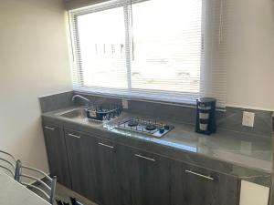 Una cocina con estufa, fregadero y ventana. en Casa Mezquite, en Tequisquiapan 12 fotos más