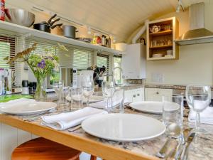 a kitchen with white plates and glasses on a counter at Sprat & Winkle in Horsebridge