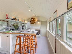 a kitchen with two bar stools and a counter at Sprat & Winkle in Horsebridge +29 photos