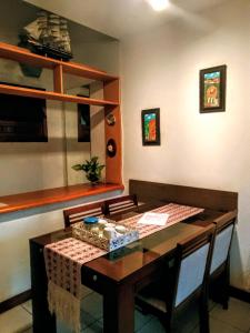 a dining room with a table and chairs and a shelf at Casamarela in Paraty +62 photos