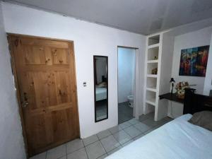 1 dormitorio con puerta de madera y espejo en Vicky's Room - NO PARKING SITE, en Santiago Este