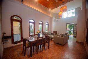 a living room with a table and chairs and a couch at The Living Villa in Badulla