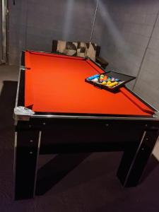 a red pool table with cue balls on it at Espaço de Lazer Poço Valioso in Mogi das Cruzes