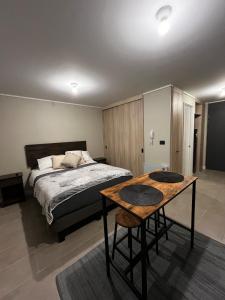 een slaapkamer met een bed en een houten tafel bij depto no dispo in Los Ángeles +1 foto