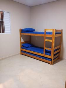 a bunk bed in a room with blue pillows at Espaço de Lazer Poço Valioso in Mogi das Cruzes