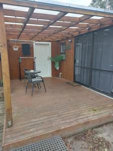 a patio with a wooden deck with a table at Rural in the city in Palmerston North +29 photos