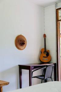 a room with a desk and a guitar on the wall at Baan Nai Bang in Suratthani
