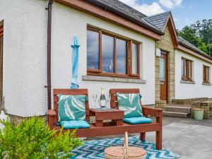 un banco de madera con una mesa y una sombrilla en Trelaw - Uk41532, en Ochiltree